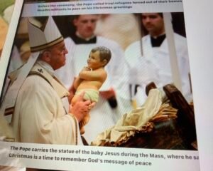Pope admiring the plastic image baby Jesus Christ